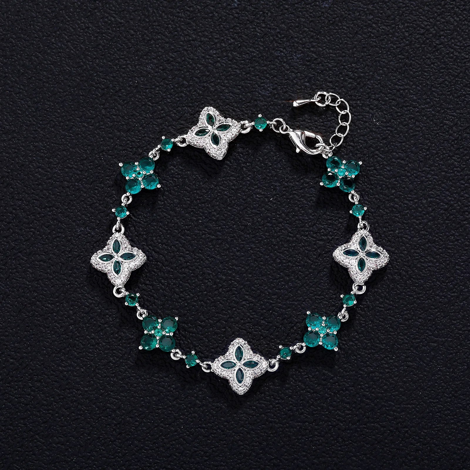 Four-Leaf Clover Bracelet with emerald-green stones in silver-tone setting and adjustable chain.